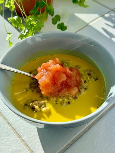 a bowl of soup with a spoon in it at Udden Retreat-Bed & Breakfast in Skinnskatteberg