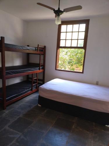 une chambre avec deux lits superposés et une fenêtre dans l'établissement Suite na mansão Ilhabela, à Ilhabela