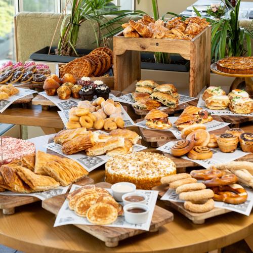 a table full of different types of pastries and bread at Hilton Garden Inn Athens Syggrou Avenue in Athens
