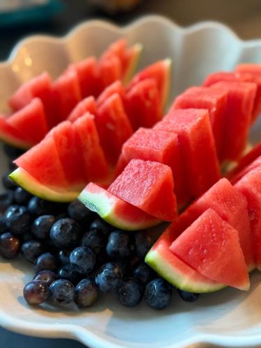 a plate of watermelon and blueberries and watermelon slices at Udden Retreat-Bed & Breakfast in Skinnskatteberg