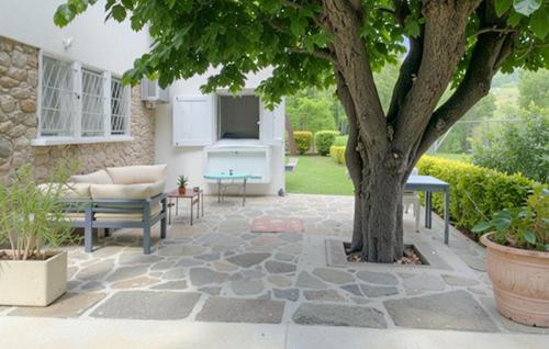 un patio avec un arbre, un canapé et une table dans l'établissement Nice Apartment In Erbalunga With Wifi, à Erbalunga