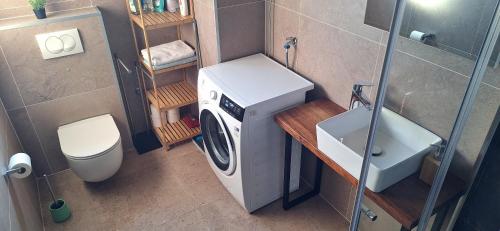 a small bathroom with a washing machine and a toilet at Modern apartment in Biograd na Moru