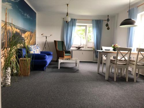 ein Wohnzimmer mit einem blauen Sofa und einem Tisch in der Unterkunft FeWo Ferienwohnung Travequelle Whg Backbord Gießelrade Holsteinische Schweiz Ostsee Nähe Scharbeutz in Ahrensbök