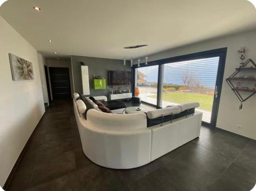 una gran sala de estar con un gran sofá blanco en Chambres dans villa à 10 minutes de Crans-Montana, en Chermignon-dʼen Haut