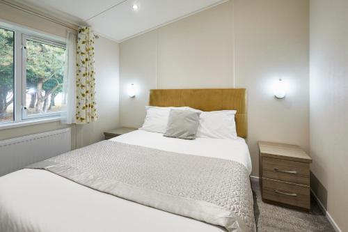 une chambre avec un grand lit et une fenêtre dans l'établissement Reynards Retreat Lodge with Hot Tub, à Barmby on the Moor