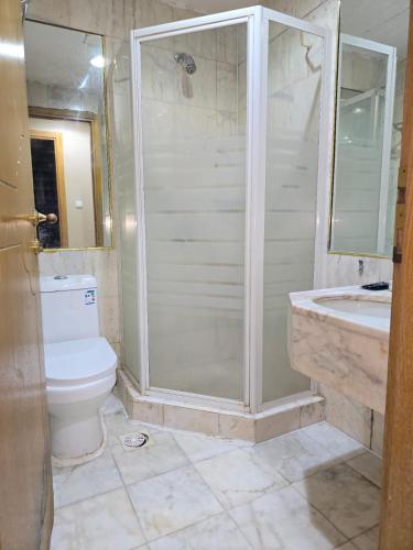 a bathroom with a shower and a toilet and a sink at برج الجوار السكني أجياد المصافي Jiwar Tower Ajyad Al Masafi in Al Gharīth
