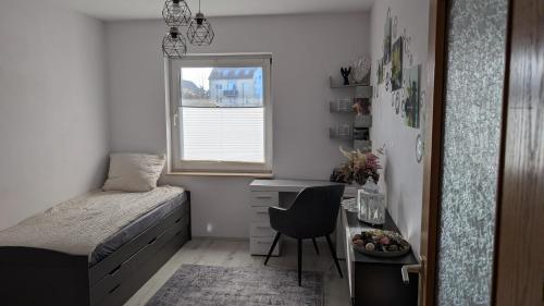 ein Schlafzimmer mit einem Bett, einem Schreibtisch und einem Stuhl in der Unterkunft Ferienwohnung Schusi Kesselsdorf in Kesselsdorf