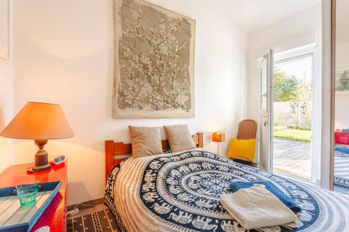 a bedroom with a bed and a table with a lamp at Chambre Indépendante dans Maison in Le Château-dʼOléron