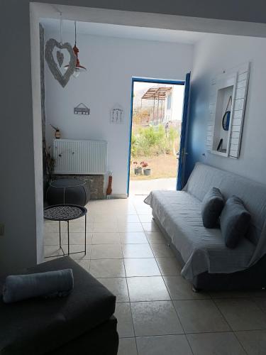 a bedroom with a bed and a living room at Eco Haus Milatos in Mesochórion