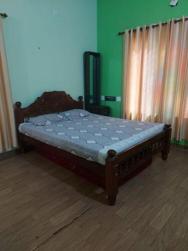 a large bed in a bedroom with a wooden floor at Aura Eco Friendly Resort in Sultan Bathery
