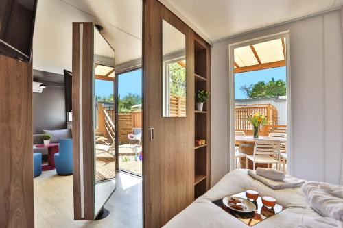 ein Zimmer mit einem Bett und einem Wohnzimmer in der Unterkunft Camping Les Peupliers in La Flotte