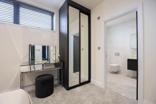 ein Badezimmer mit einem Spiegel, einem Waschbecken und einem WC in der Unterkunft Elliot Oliver - Stunning 4 Bedroom Home with Parking in Cheltenham in Cheltenham