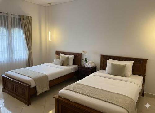 two beds in a hotel room with at Gianyar Hotel in Gianyar