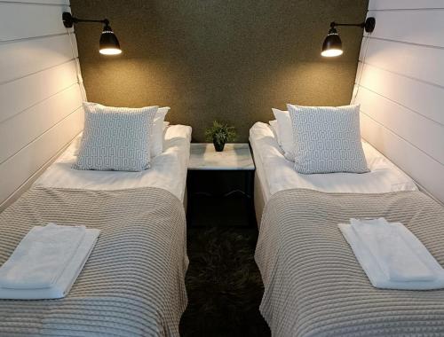 two beds sitting next to each other in a room at Top-equipped Kaarna Spa Villa in Inhantehtaat