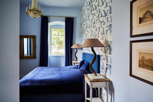 a blue bedroom with a bed and a window at Schloss Hotel Alte Rentkammer in Birstein