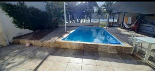 ein großer Swimmingpool auf einer Terrasse mit einem Tisch und einem Tisch in der Unterkunft casa dos MORAIS in Angra dos Reis
