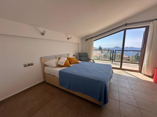 ein Schlafzimmer mit einem Bett und einem großen Fenster in der Unterkunft Marvelous Seaview Villa Lemon Kalkan in Kalkan