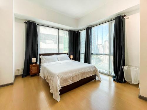 Sampongcorner 1BR unit with city view Avant at The Fort的一间配有大床和大窗户的卧室