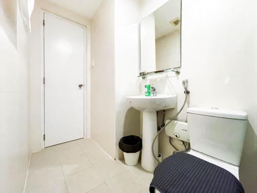 Sampongcorner 1BR unit with city view Avant at The Fort的浴室里有马桶、洗手池和镜子。