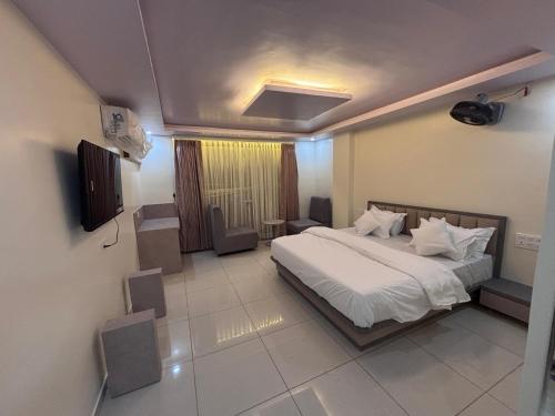 Un dormitorio con una cama y un televisor. en NR Hotel, en Rīngas