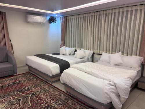 Una habitación de hotel con dos camas y una ventana. en NR Hotel, en Rīngas