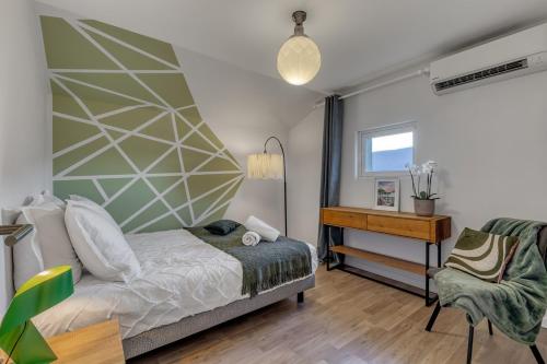 une chambre avec un lit et un bureau dans l'établissement Maison de charme - Vues Montagnes - Aix-les-Bains, à Aix-les-Bains