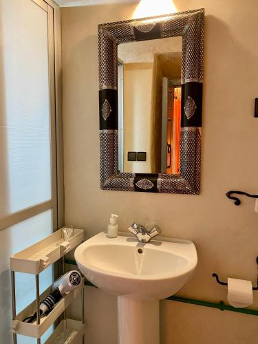 a bathroom with a sink and a mirror at Nomadic Birdway in Imiter