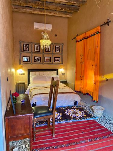 a bedroom with a bed and a chair and a desk at Nomadic Birdway in Imiter