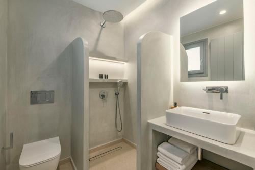a white bathroom with a sink and a toilet at La Maltese Central in Naousa
