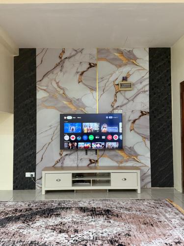 ein Wohnzimmer mit einem Flachbildfernseher an der Wand in der Unterkunft coach homestay 2 in Kuantan