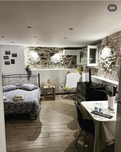 a bedroom with a bed and a table and chairs at Sofisstudios in Mytilene