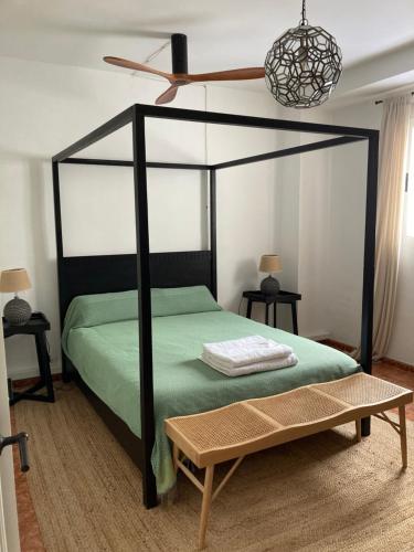 a bedroom with a black canopy bed and a table at Casa Entre Lunas - Stylish Rustic Retreat in Olvera