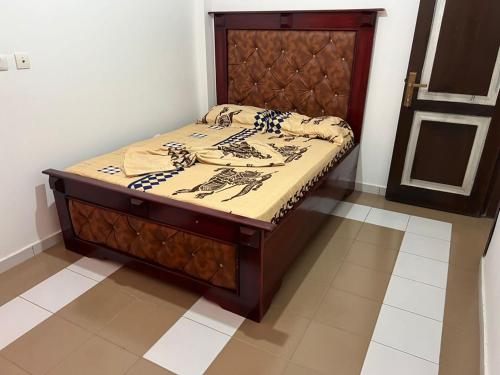 a bed in a room with a wooden frame at Janamaev in Yaoundé