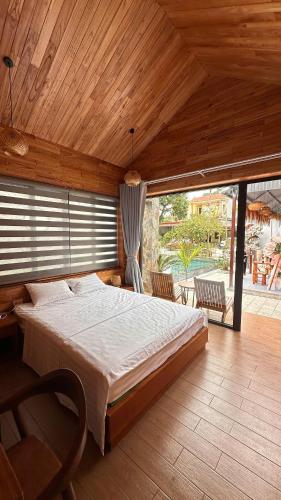 a bedroom with a large bed with a wooden ceiling at Avana House in Nguyên Ngoại