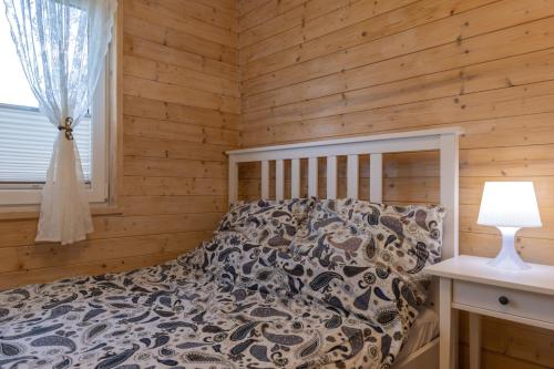 a bedroom with a bed in a wooden wall at Apartamenty przy winnicach - blisko term - świetny wybór dla rodzin z dziećmi - mówimy po polsku! in Bogács