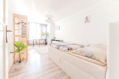 多瑙河畔克雷姆斯Central apartment by Train Station Krems的白色的卧室设有一张大床和一个楼梯