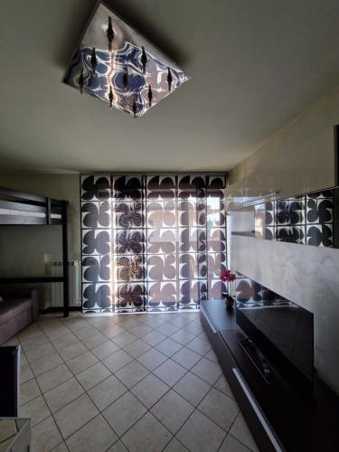a living room with a chandelier and a tile floor at Casa di Mike in Canegrate