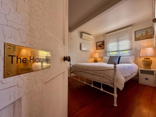 a bedroom with a bed with a sign on the wall at Kilkivan Homestead in Kilkivan
