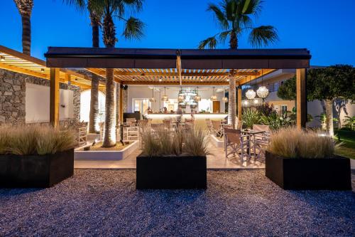 a patio with palm trees and a house at Cirillo Family Hotel-Christinas Studios in Mastichari