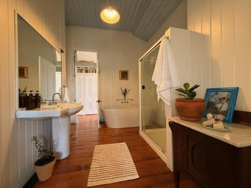 a bathroom with a sink and a shower and a tub at Kilkivan Homestead in Kilkivan