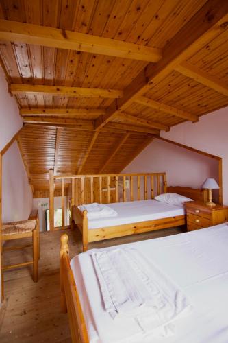 two beds in a room with wooden ceilings at Xi Village in Xi