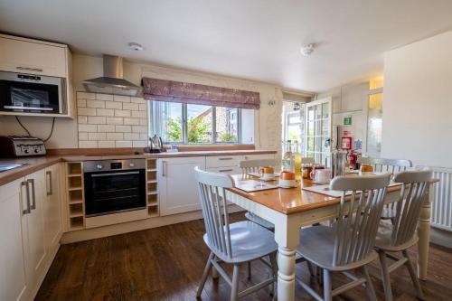 a kitchen with a table and chairs in a kitchen at Middlewick Holiday Cottages in Glastonbury