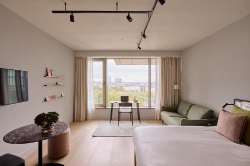 un salon avec un lit et une table dans l'établissement Wilde Aparthotels Amsterdam Noord, à Amsterdam
