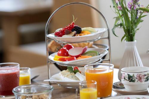 Una bandeja de fruta en una mesa con bebidas. en Hotel Konradshof, en Seewald