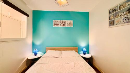 a bedroom with a blue wall and a bed at L'air de Stella-Plage au coeur de la Station Balnéaire in Stella-Plage