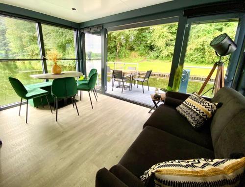 a living room with a couch and a table and chairs at Houseboat Marina Mookerplas 4-6 persoons (met hottub en dakterras) in Middelaar