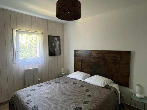 ein Schlafzimmer mit großem Bett und Fenster in der Unterkunft Appartement T2, très bien équipé, avec terrasse, jardin, et accès piscine in Cambo-les-Bains