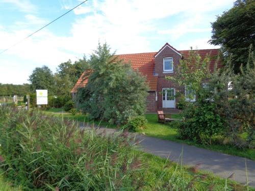 a red brick house with a bench in front of it at Marijanas Ferienhof 1, Urlaub mit viel Platz zwischen Dornumersiel und Bensersiel, gehört zum Café Kunterbunt in Middelsbur