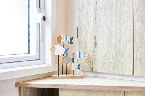 Una figurita de madera con forma de conchas sobre un mostrador junto a una ventana en Squirrel Lodge with Hot Tub, en Pocklington