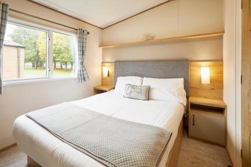 Un dormitorio con una cama grande y una ventana en Squirrel Lodge with Hot Tub, en Pocklington
